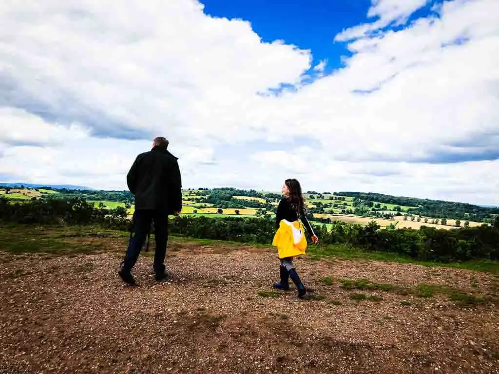father and daughter at top of hill in countryside