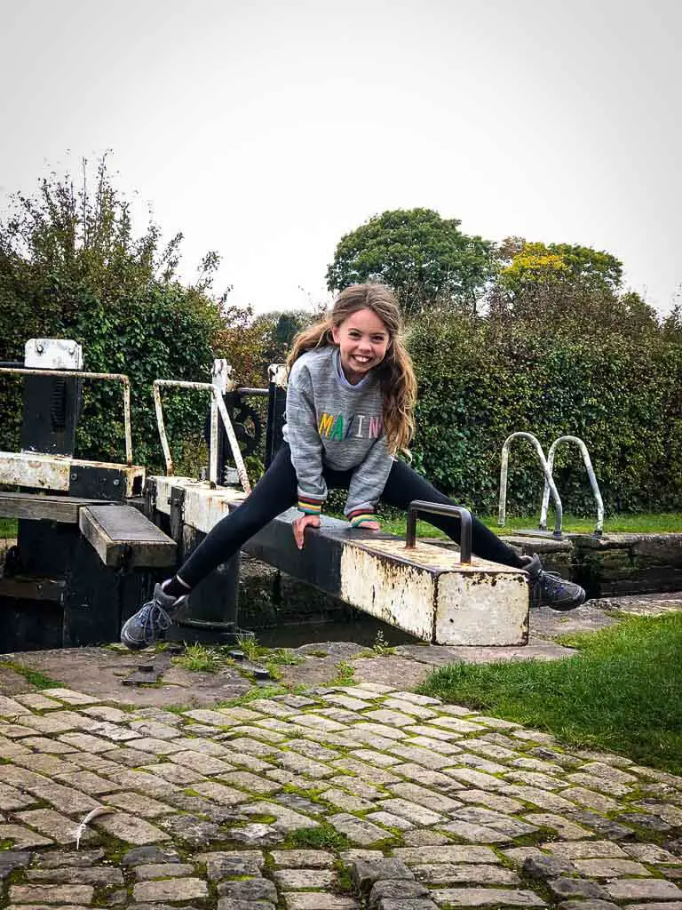 girl balancing on hands on a canal lock
