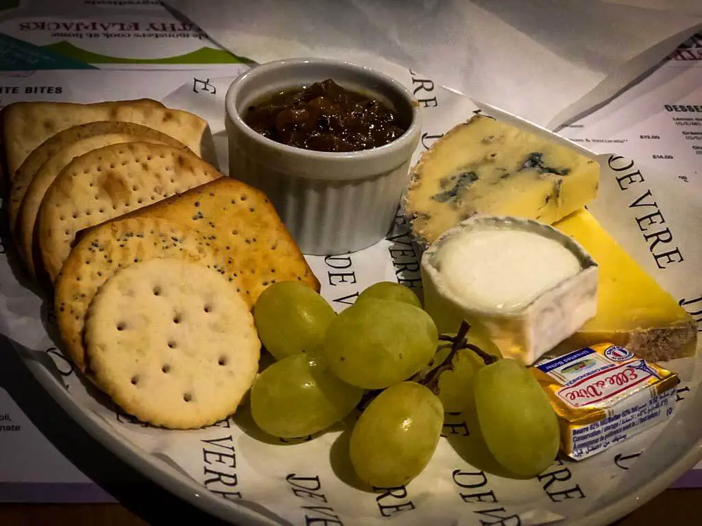 cheese board with crackers, grapes and a variety of cheese