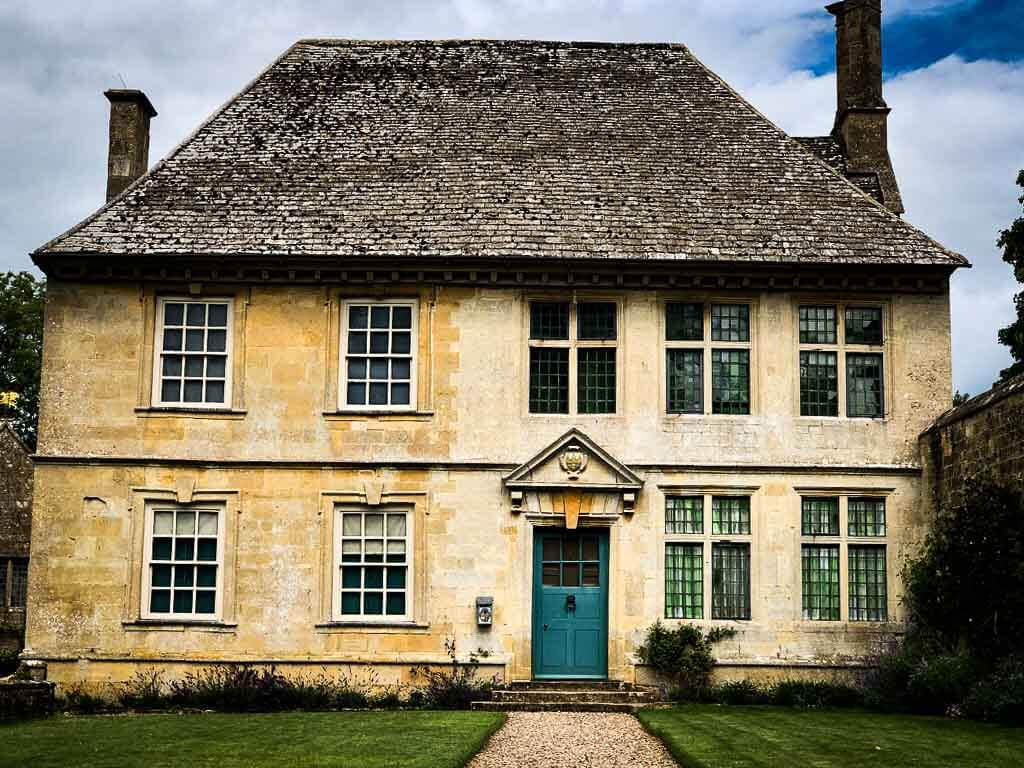 cotswolds stone stately home with bright green door