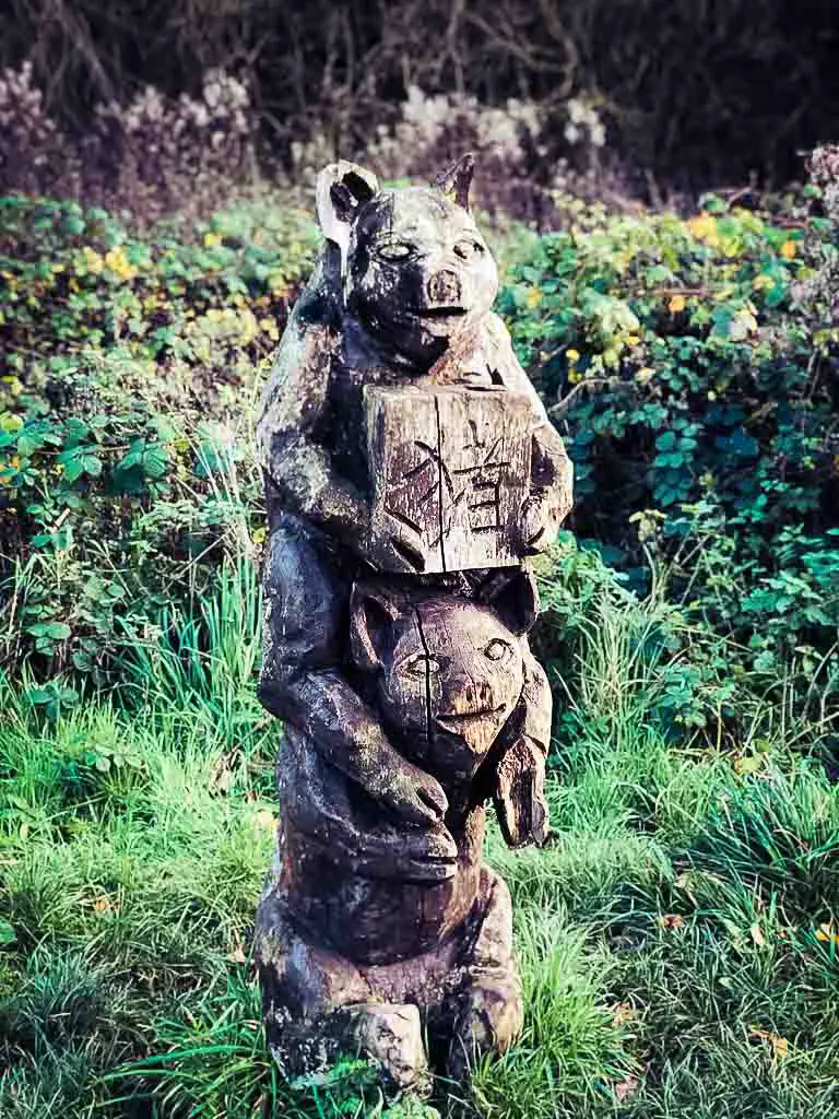 wooden sculpture of twonpigs, one on top of the other