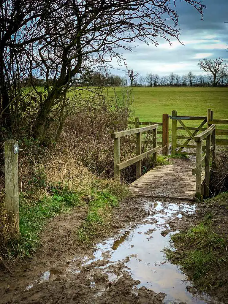muddy route across a small wooden bridge
