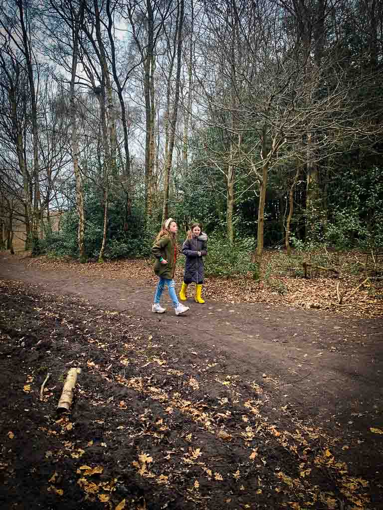 two young girls walking through the woods