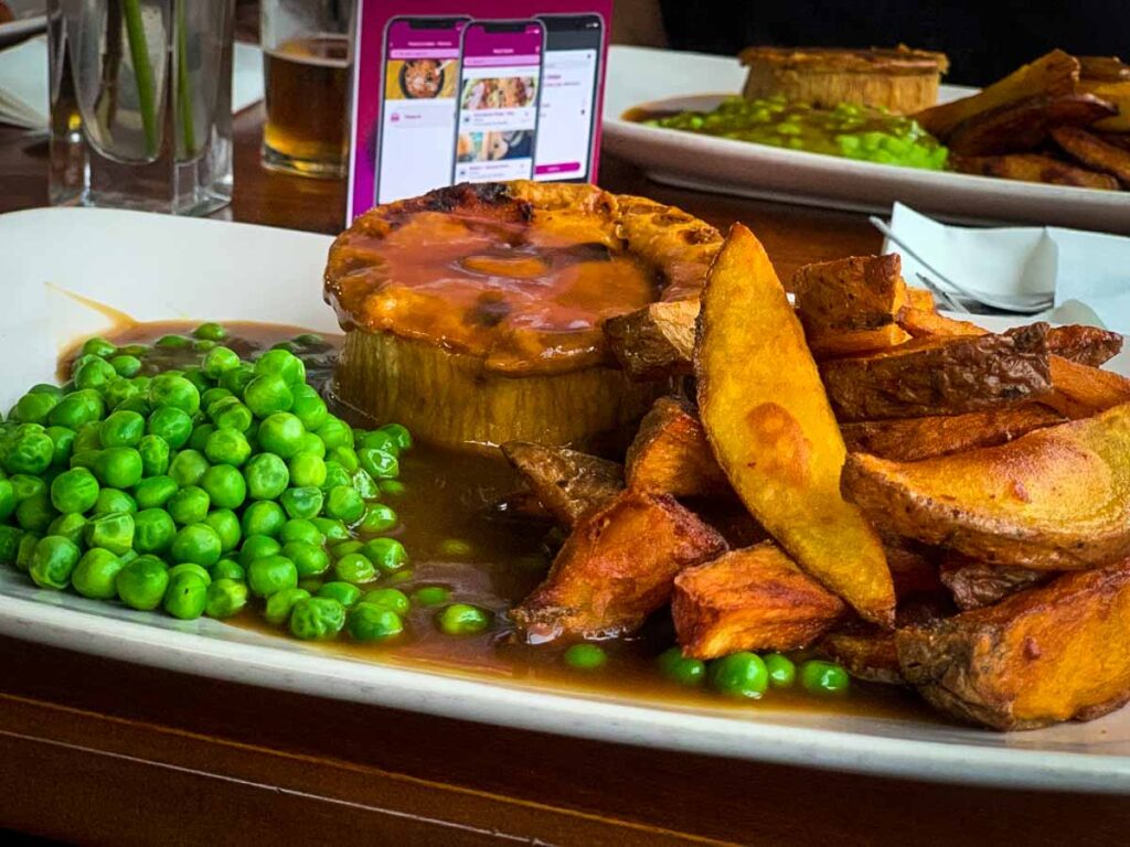 plate of pie, chips, peas and gravy