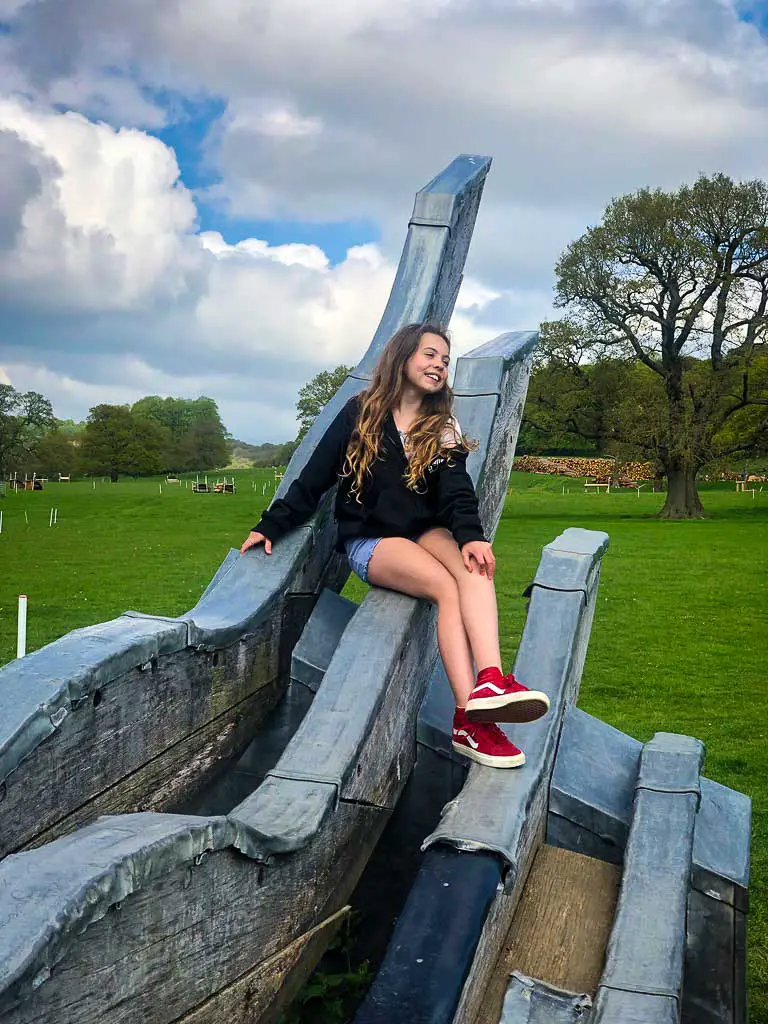 piper quinn sat on a sculpture at chatsworth