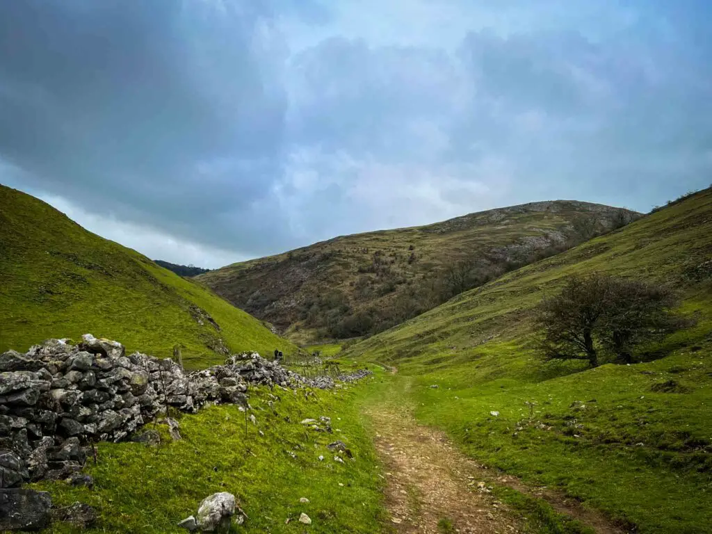 pathway through two grassy peaks heading away from Dovedale